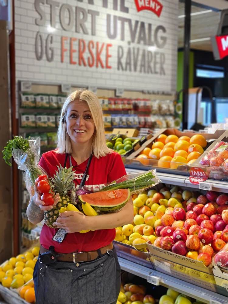 Ansatt på Meny viser frem frukt