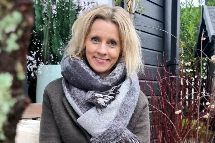 Kvinne, Marita Ryland poserer for et bilde i hagen sin.