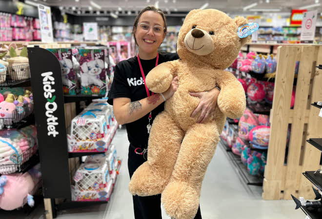 Dame som holder stor teddybjørn