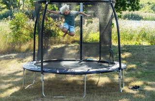 Gutt som hopper på en trampoline