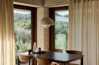 En hvit taklampe og to beige gardiner