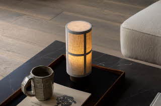 Bordlampe på stuebord med kopp og blader.