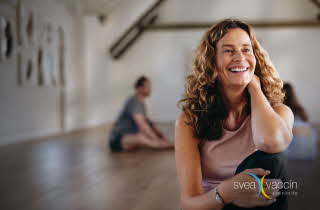 Dame som sitter innendørs med logoen Svea Vaccin.