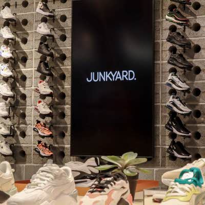 Vegg med sneakers, svart skjerm med Junkyard logo