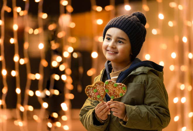 Gutt som holder to pepperkakehjerter