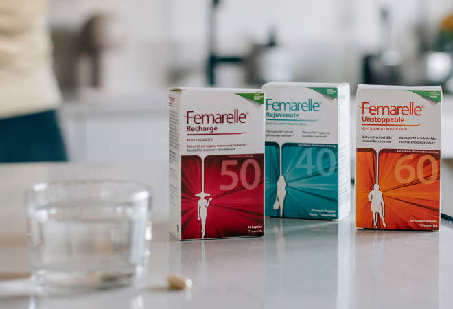 Tre pakker med forskjellig type Femarelle står på en kjøkkenbenk med et glass vann
