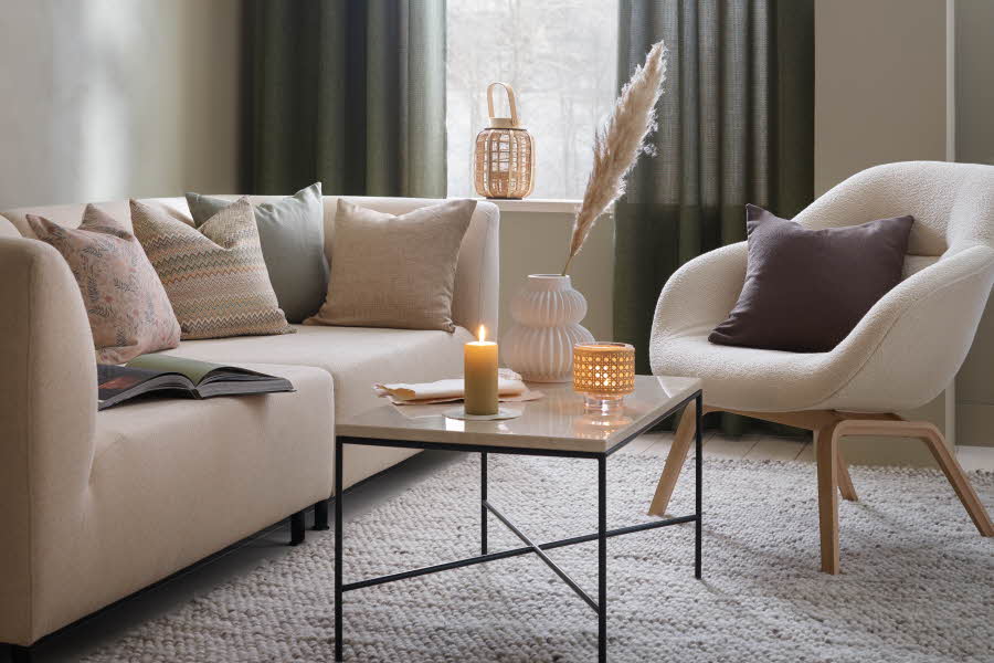 stue med beige sofa og stol og lyse puter