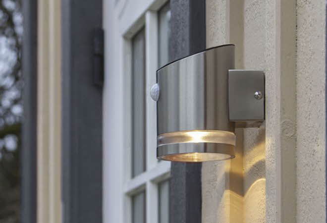 En solcellelampe som er montert ute på et hus