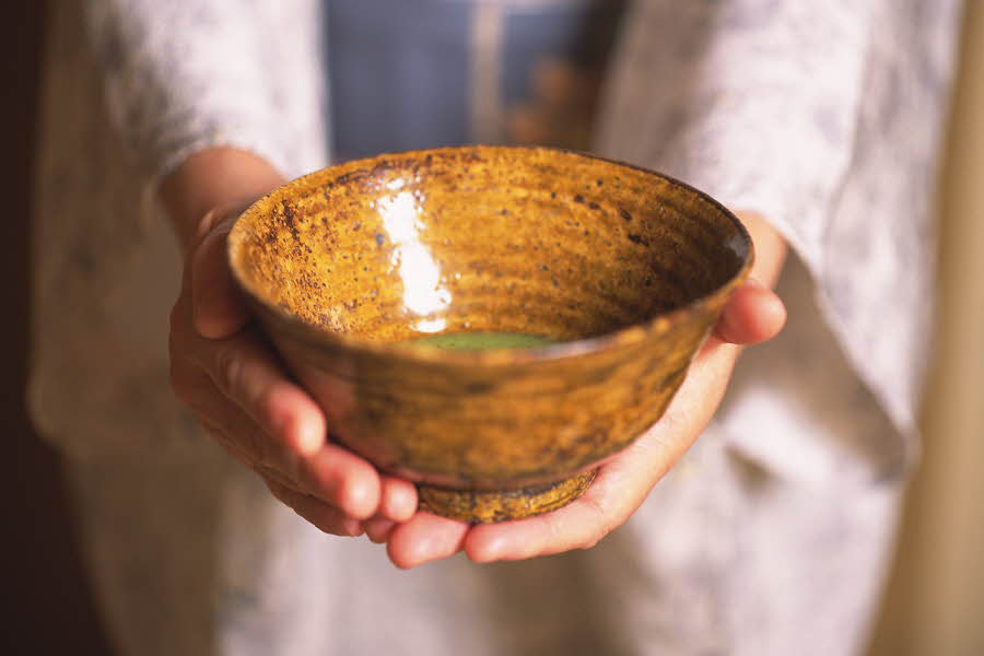 Kvinne holder fram en keramikkskål