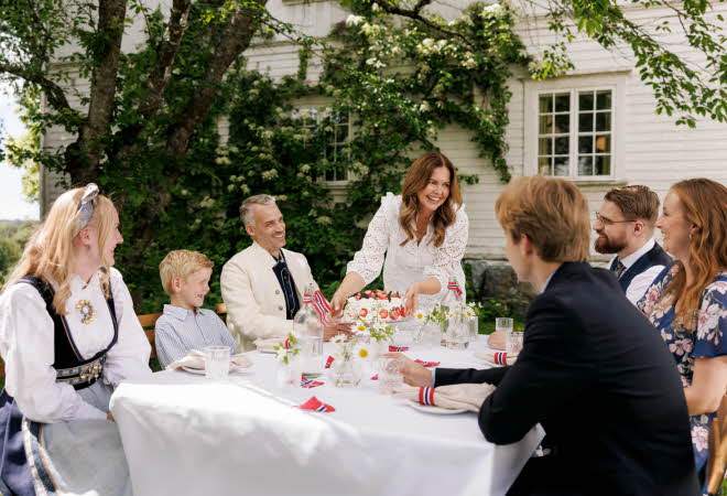 Familie til bords utendørs som feirer 17. mai
