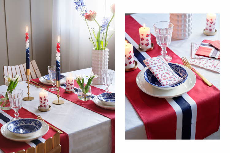 Bord med hvit duk, løper i flaggets fager, hvit tallerken, blå bolle, mønstret serviett, vinglass, lysestaker med rød, hvite og blå stearinlys, vase med blomster, kubbelys og små vaser med hvite blomster.