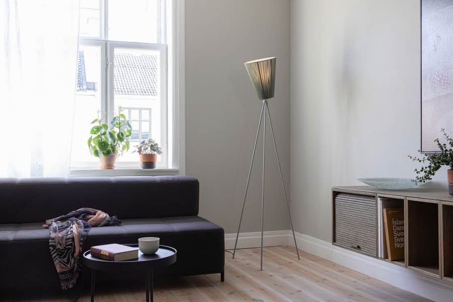 En mørkfarget sofa og designlampen Oslo-lampen