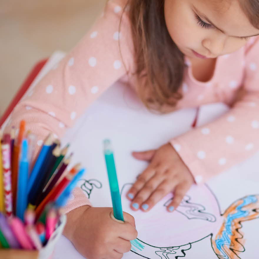 Liten jente fargelegger en tegning