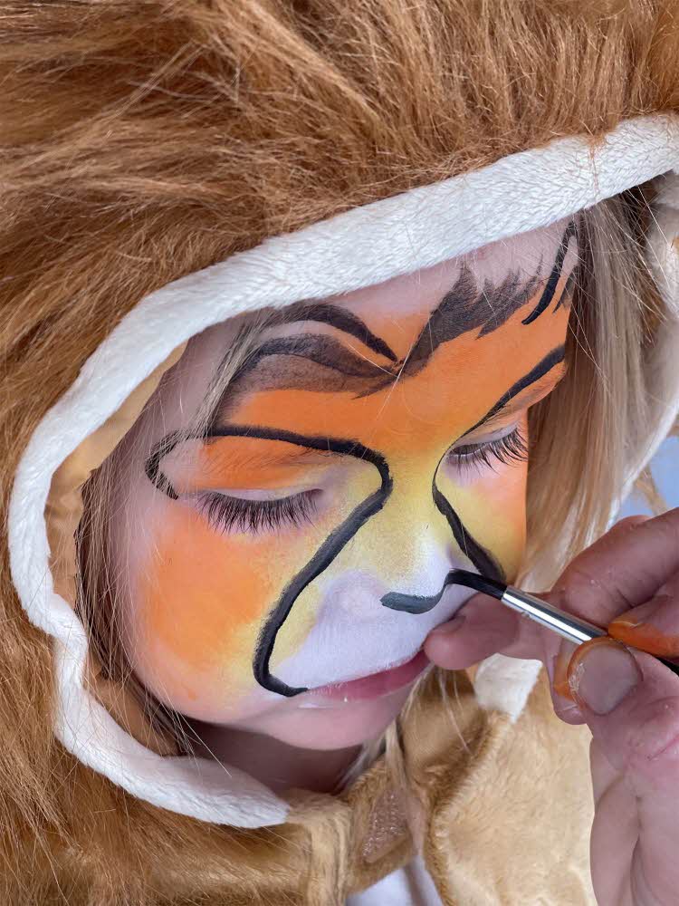 Jente som får ansiktet sitt malt til karneval