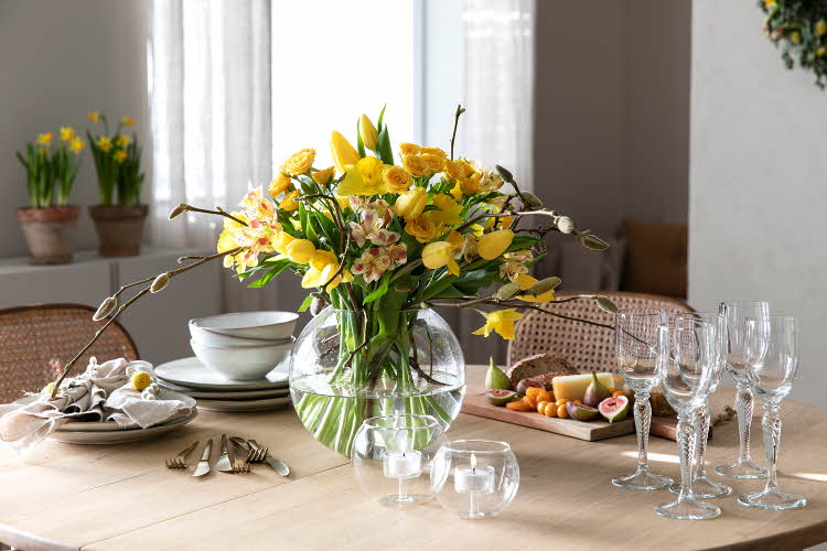Dekorert bord med service og påskeliljer i en vase
