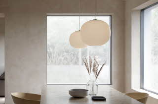 Spisestue med to store pendellamper over marmorbord.