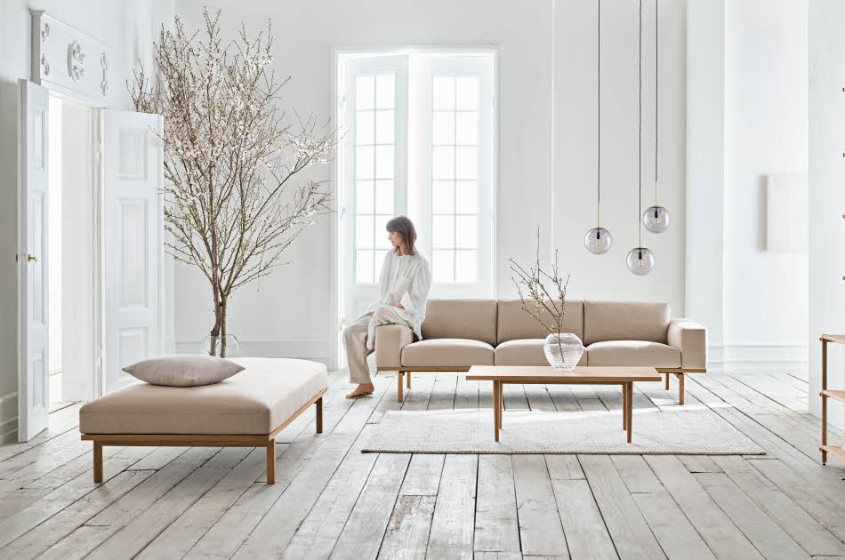 Stue hvitmalt, med tre i stua + sofa + pendler i hjørnet. Utstilling fra Bolia