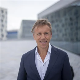 Portrett av Eirik Kildal. Han har på blå dress og smiler. 