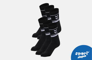 Seks svarte sokker med hvite striper og chevron-mønster.