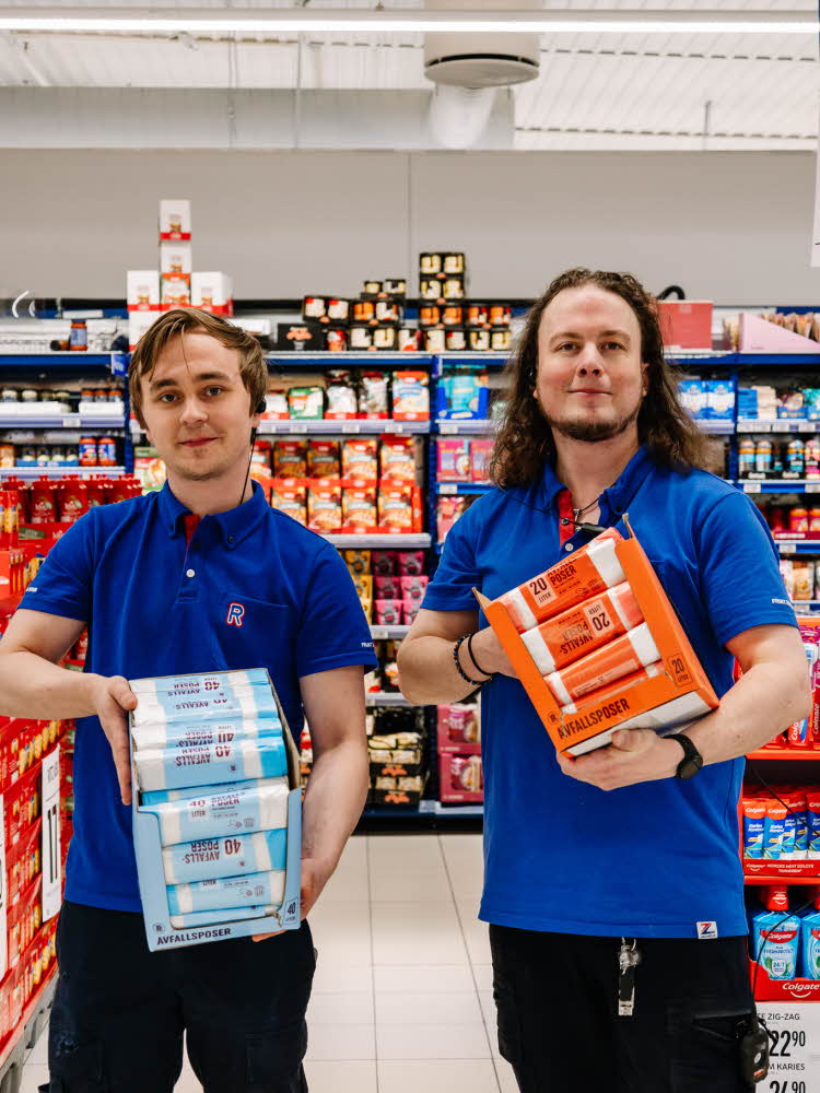 Menn fra Rema 1000 som holder avfallsposer på rull