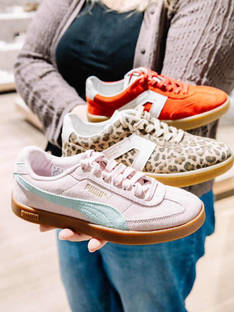 Dame som holder sneakers