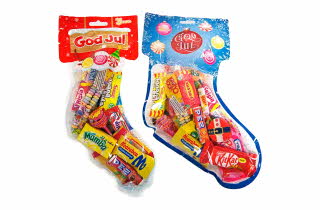 To gjennomsiktige julestrømper fylt med assortert godteri og merket med «God Jul».