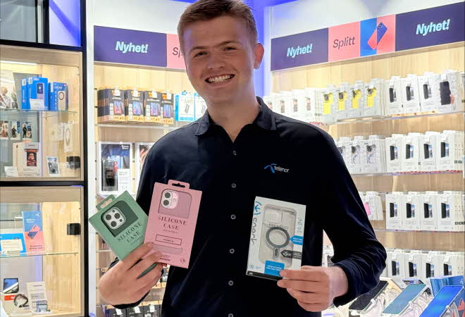 Mann fra Telenorbutikken holder deksler til mobiltelefon