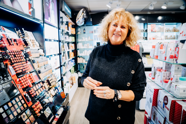 ansatt viser frem ulike sminkeprodukter