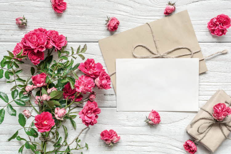 Konvolutt og kort ved siden av blomster