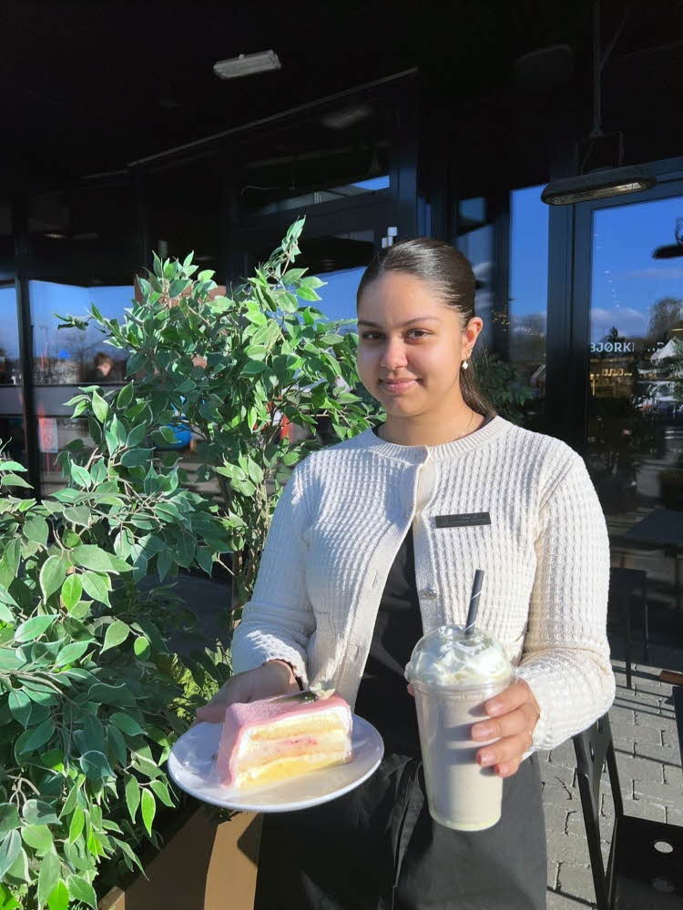 Dame som holder kake og milkshake