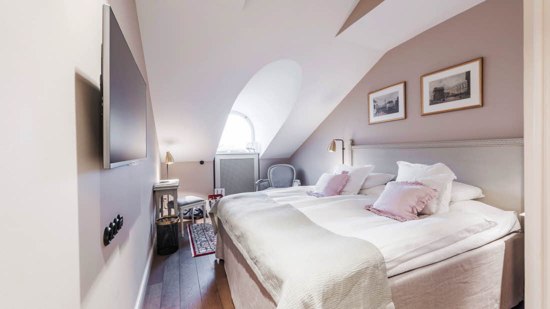 Double Room met tweepersoonskamer, een leunstoel aan beide zijden van het bed, een tv, parketvloer en een klein raam.
