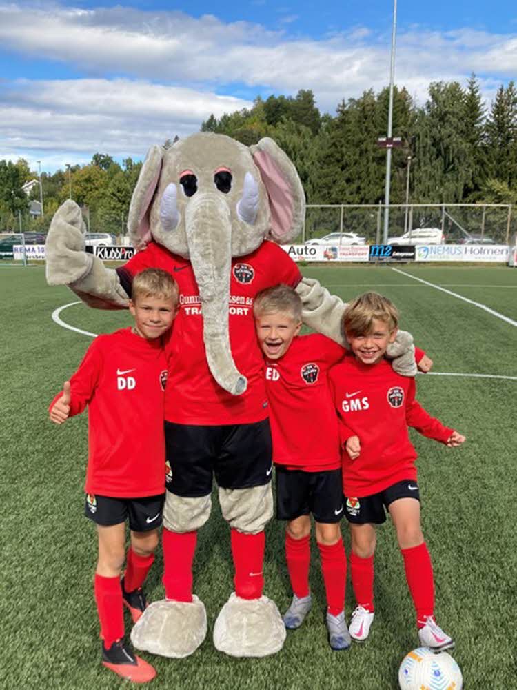 tre barn og en elefantkostyme på fotballbane