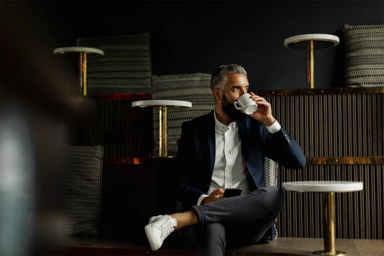 Forretningsmann drikker kaffe på kafé