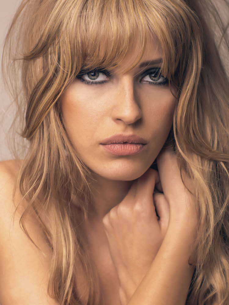 Dame med mørke sminket øyne og blondt hår