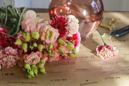 Rosa blomster og en rosa gjennomsiktig vase