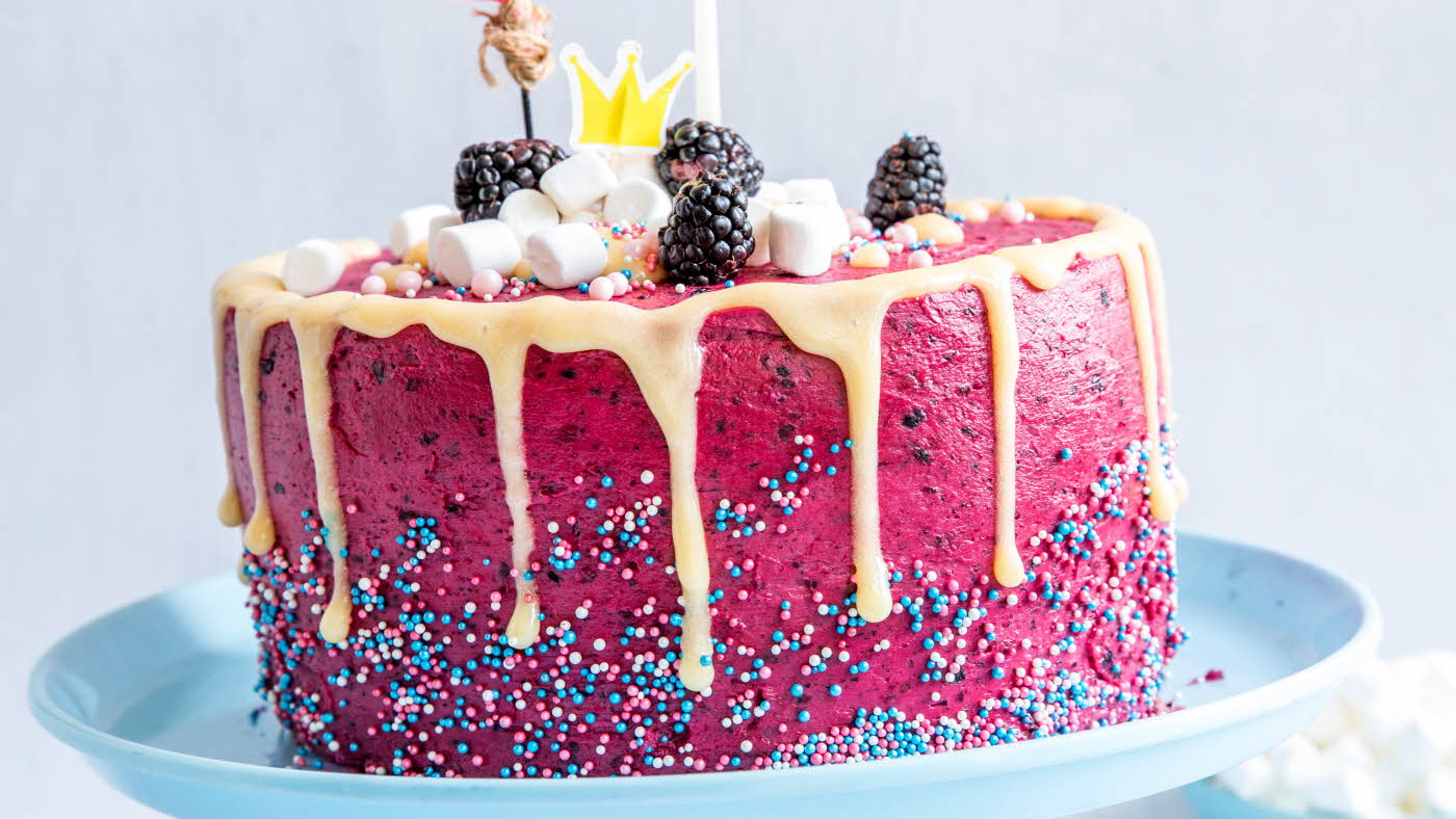 Rosa kake med skogsbærkrem, marsmellows og bær på toppen