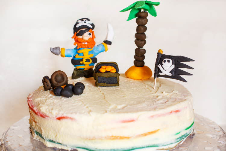En hvit kake med en sjørøver på toppen