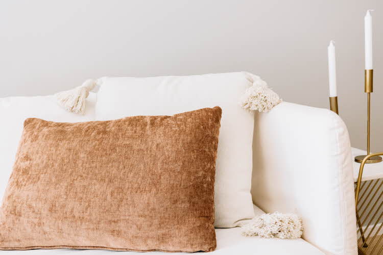 Nærbilde av beige og brun pyntepute i sofa