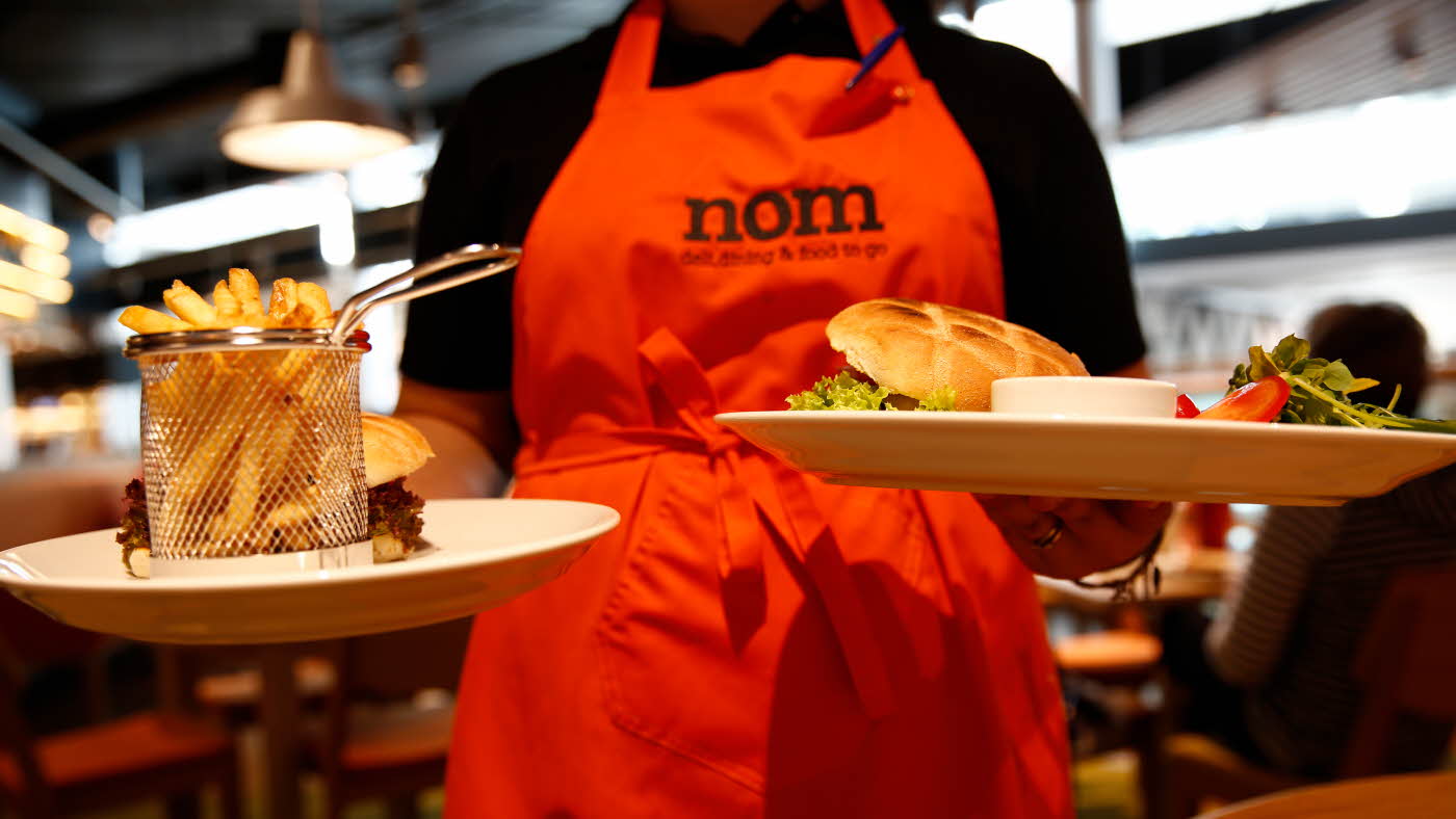 Dame serverer mat på Nom
