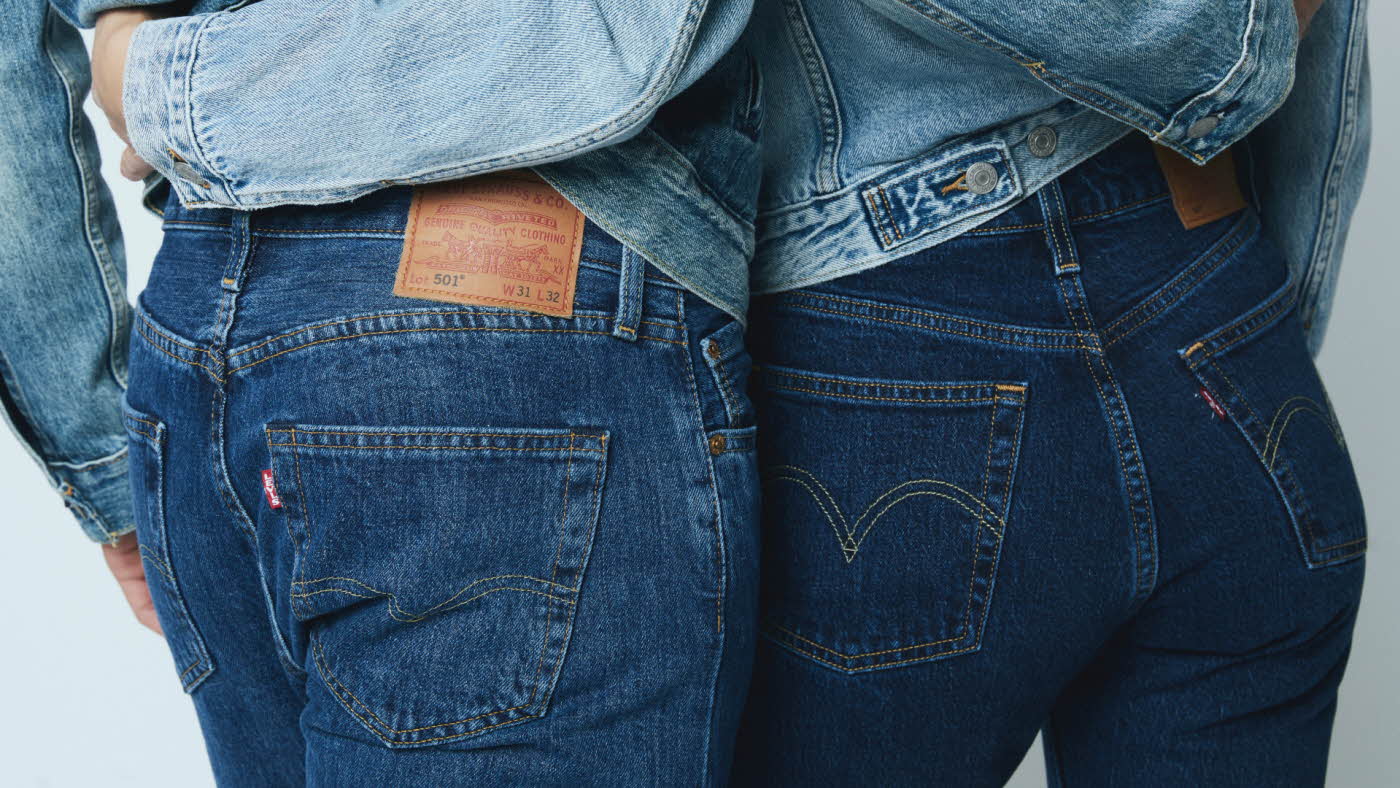 Nærbilde av bakdelen til to mennesker, hvor begge har på mørke jeans og holder rundt livet til hverandre