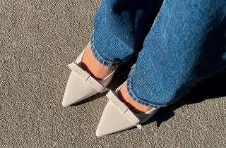 Nærbilde av føttene til en kvinne i jeans med hvite pensko