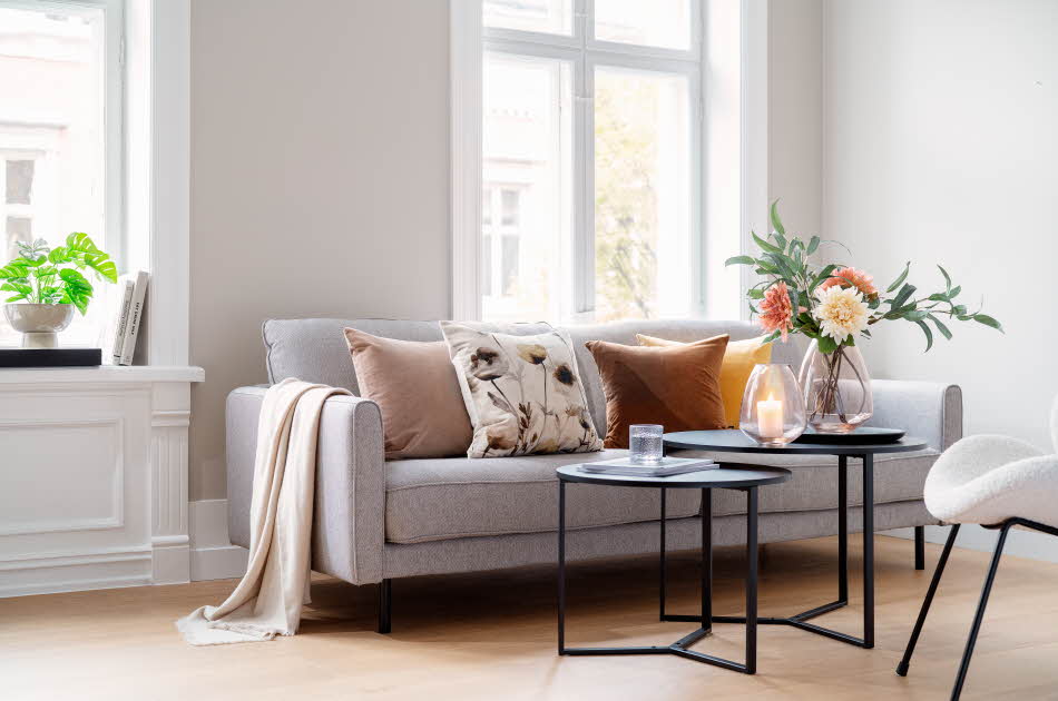 Sofa med puter og tildekket stuebord