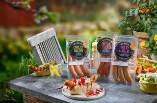 3 pakker med grillpølser og en tallerken med pølse i brød.