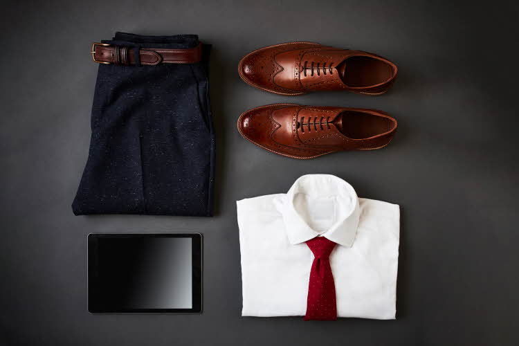 Flat lay av antrekk til herre, brettede bukser skjorte og sko