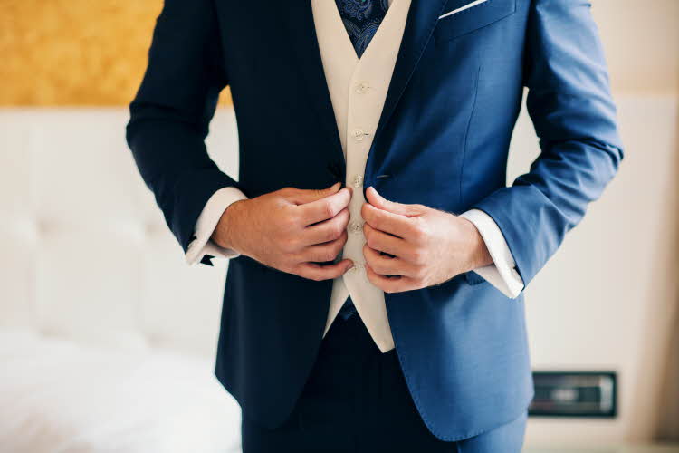 Mann i mørkeblå dress med hvit vest under