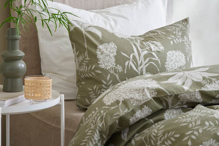 grønt sengetøy med hvitt avtrykk av blomster og planter