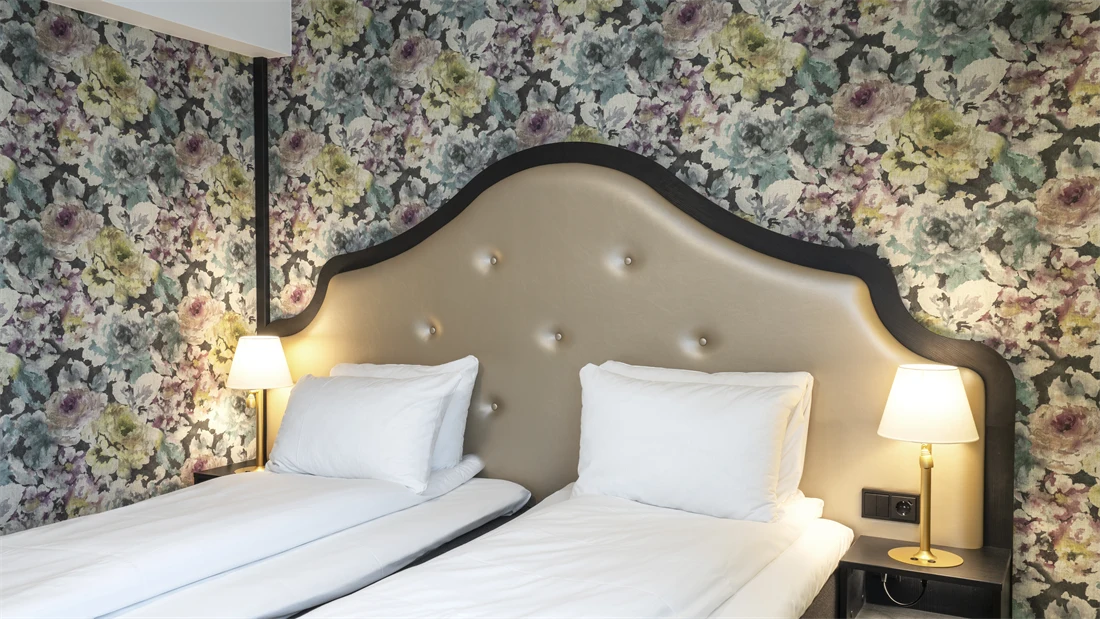 To enkeltsenger, blomstret tapet bak sengene på twin room på Thon Hotel Cecil i Oslo sentrum