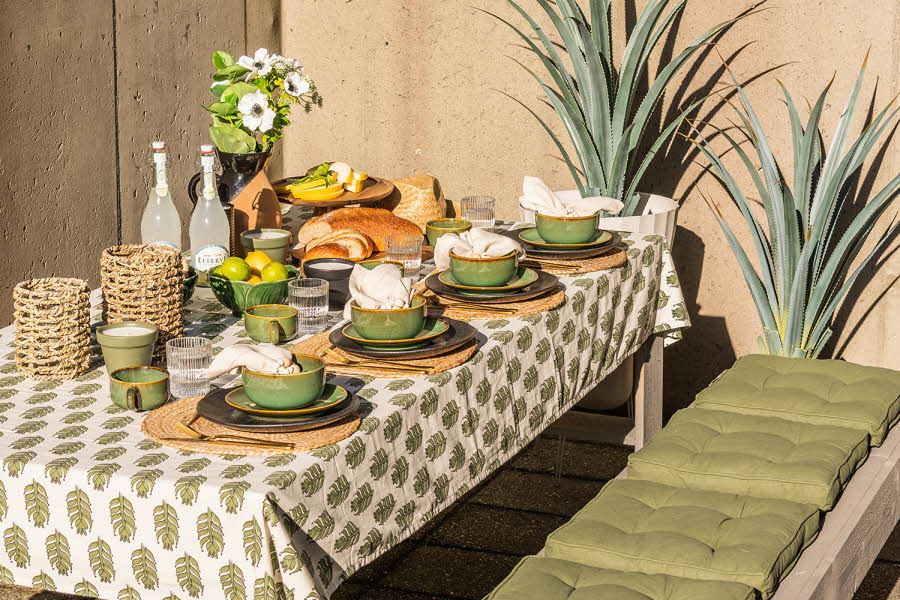 Et dekket bord med servise, kopper og mat 