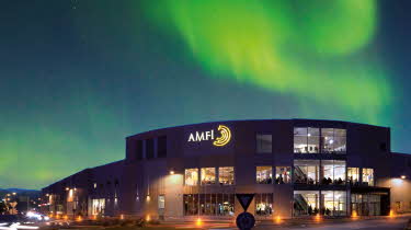 Fasadebilde med nordlys om natten av Amfi Finnsnes