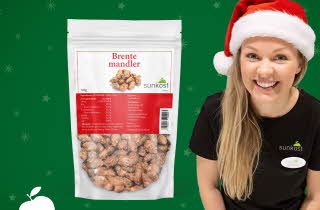 Pose med brente mandler fra Sunkost foran grønn bakgrunn med juletema.
